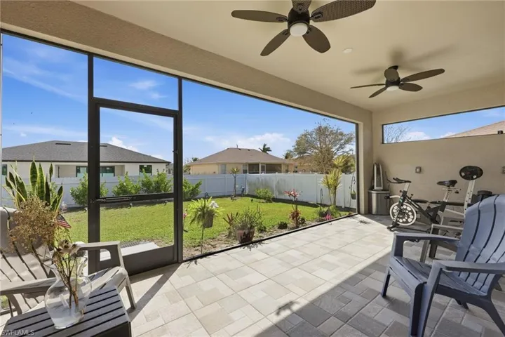 Sunroom / solarium with a ceiling fan and a patio