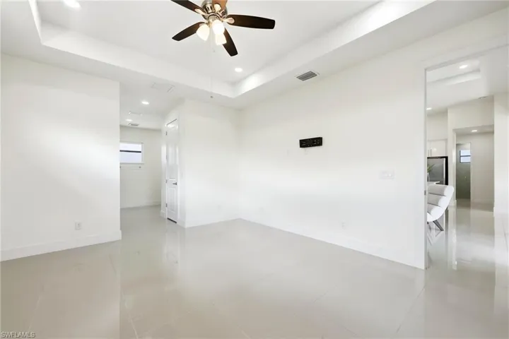 Empty room with recessed lighting, ceiling fan, a raised ceiling, and light tile patterned floors