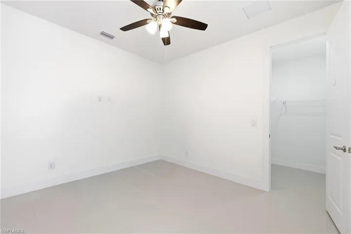 Empty room featuring ceiling fan and light tile patterned floors