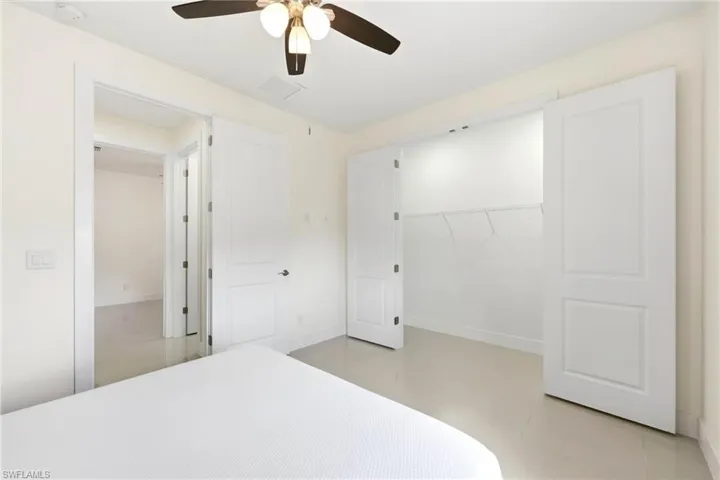 Bedroom with light tile patterned flooring, a ceiling fan, and a closet