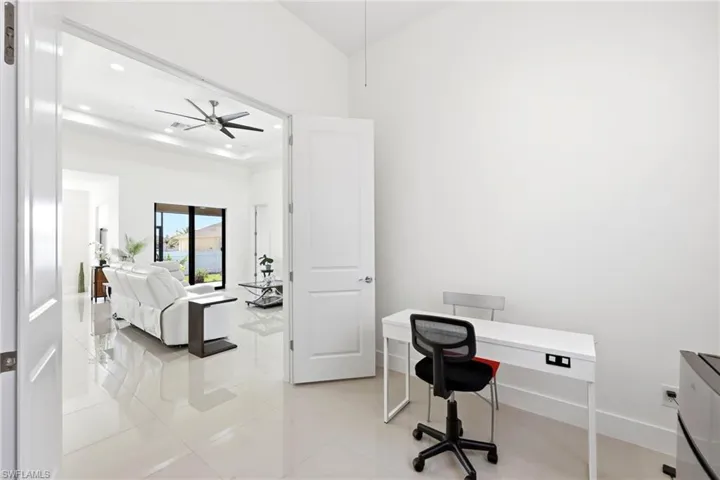 Office with light tile patterned floors, recessed lighting, a tray ceiling, and a ceiling fan