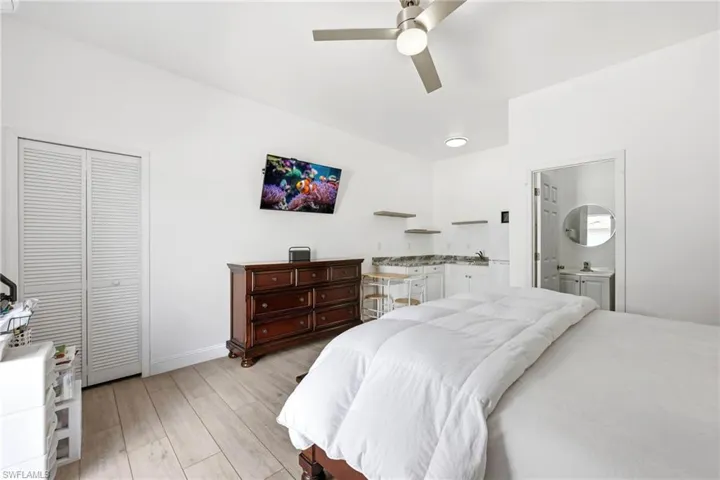 Bedroom with light wood-style flooring, ceiling fan, and a closet
