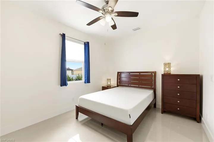 Bedroom with ceiling fan and light tile patterned flooring