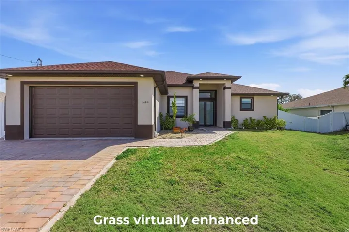 Prairie-style house featuring a garage, stucco siding, and decorative driveway