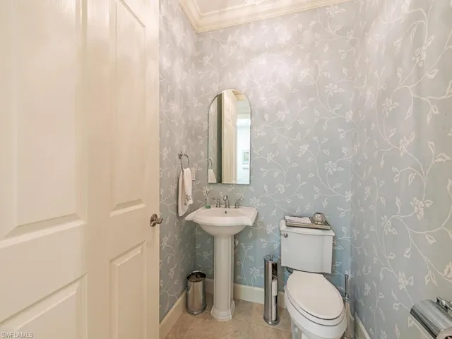 Bathroom featuring crown molding, toilet, and tile patterned floors