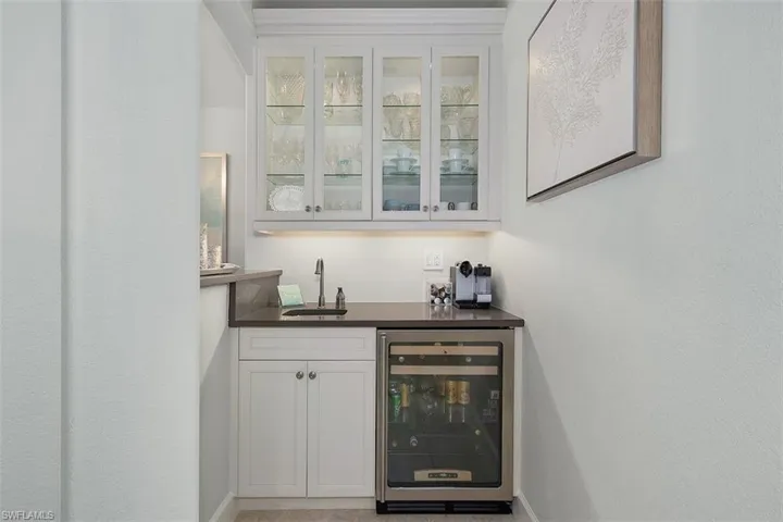 Bar with white cabinets, wine cooler, and sink
