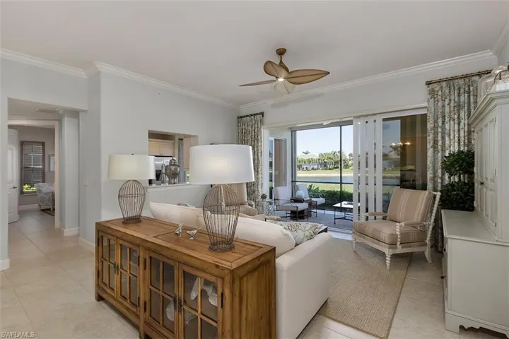 Tiled living room featuring ornamental molding and ceiling fan