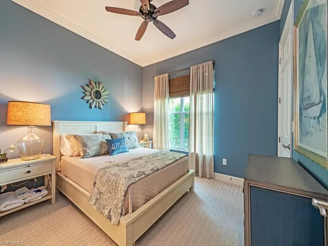 Carpeted bedroom featuring ceiling fan and ornamental molding