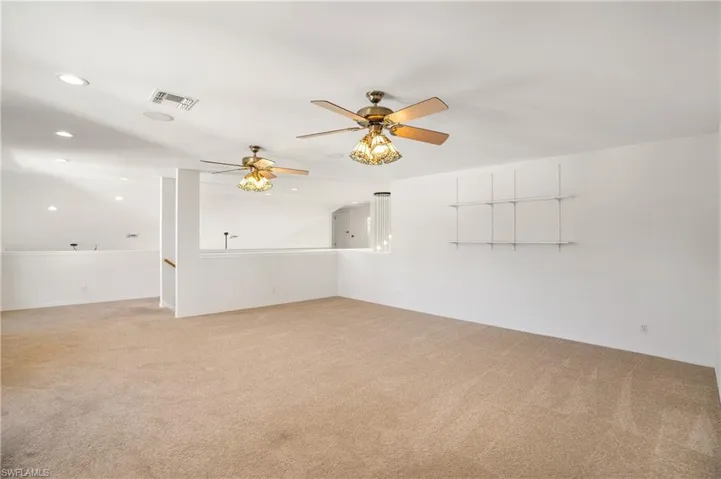 Empty room with light carpet, a ceiling fan, and recessed lighting