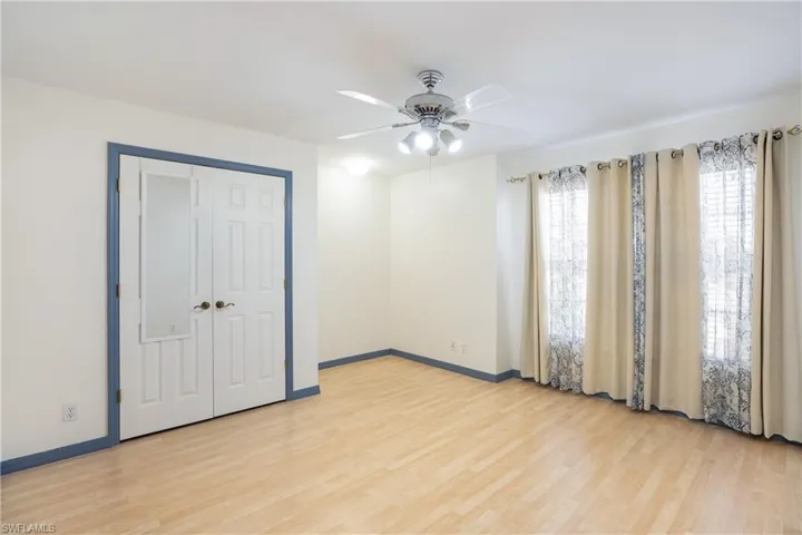 Unfurnished bedroom with light wood-style floors, a ceiling fan, and a closet