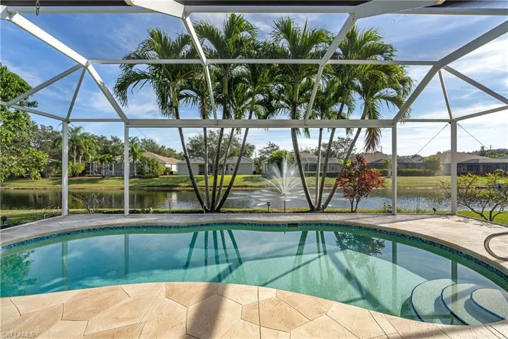 Outdoor pool with a sunroom, glass enclosure, and a water view