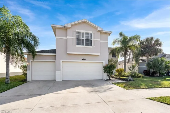 View of front of home with driveway, stucco siding, a front yard, and a garage