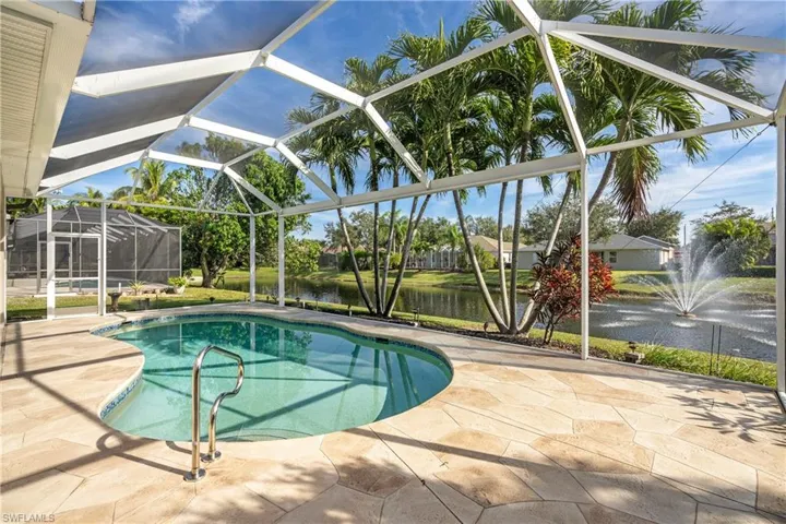 Swimming pool featuring a water view, a sunroom, glass enclosure, and a patio