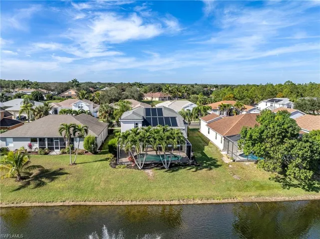 Aerial view of residential area featuring a nearby body of water