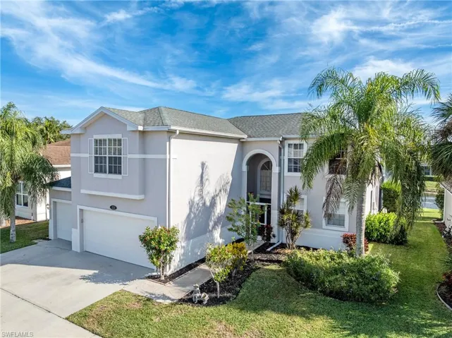 Traditional-style home featuring concrete driveway, stucco siding, an attached garage, roof with shingles, and a front yard
