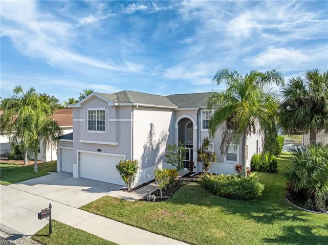 View of front of house featuring stucco siding, driveway, a garage, and a front lawn