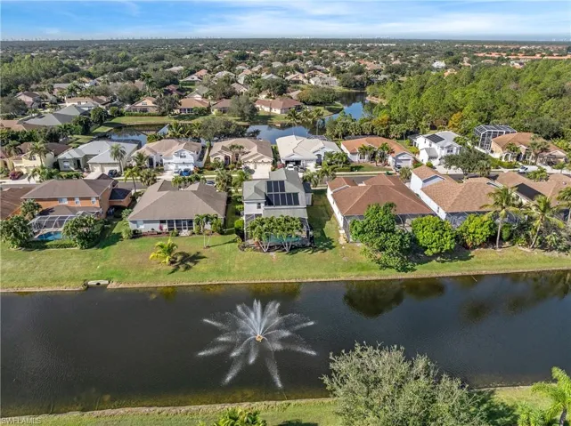 Aerial view of property's location featuring a nearby body of water and nearby suburban area