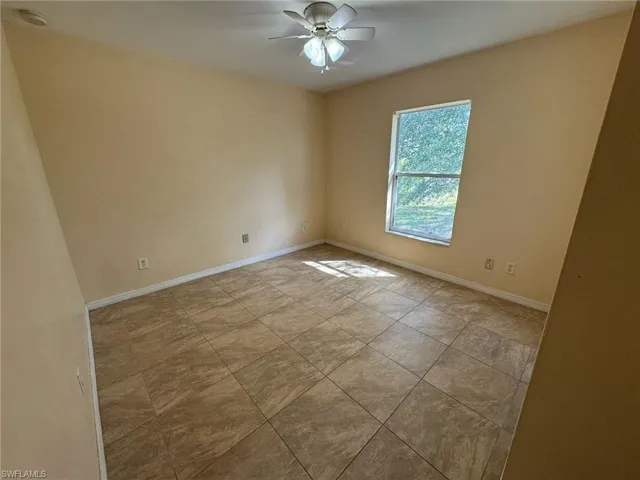 Unfurnished room with baseboards and ceiling fan