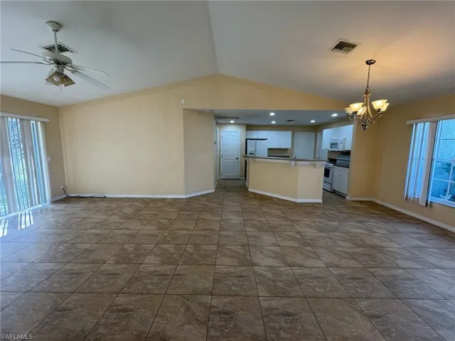 Kitchen featuring open floor plan, range with electric stovetop, visible vents, and white microwave