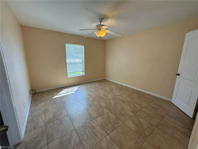 Empty room with baseboards and ceiling fan