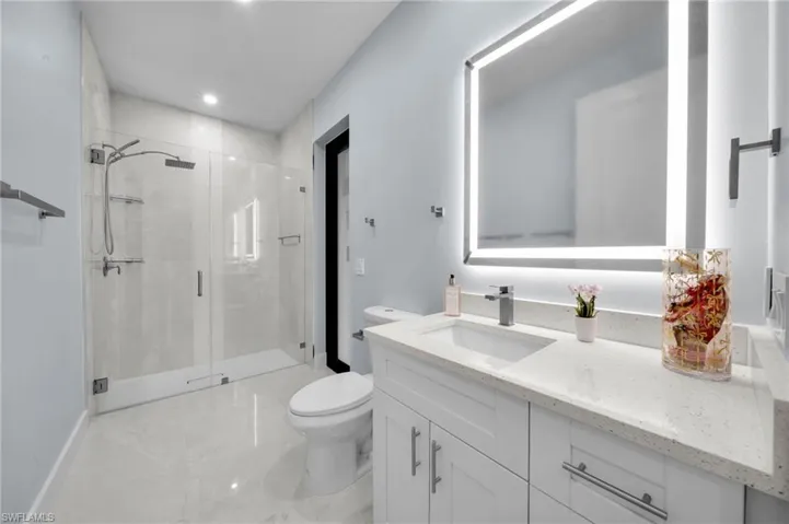 Full bathroom with vanity, recessed lighting, a stall shower, toilet, and marble finish floor