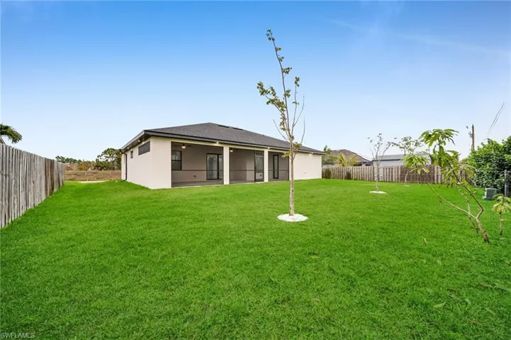 View of yard with a fenced backyard and a sunroom