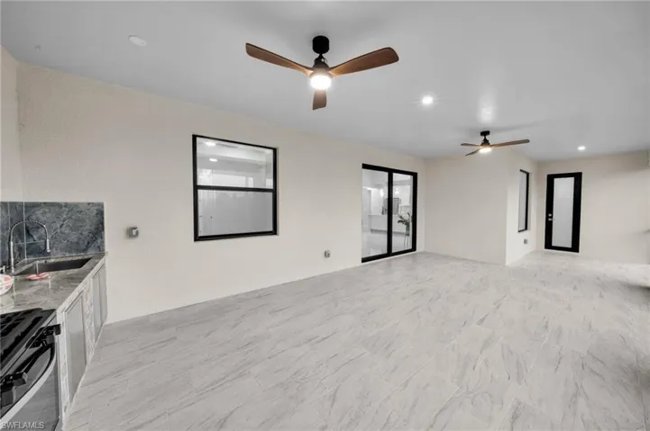 Unfurnished room featuring recessed lighting, a ceiling fan, and a sink