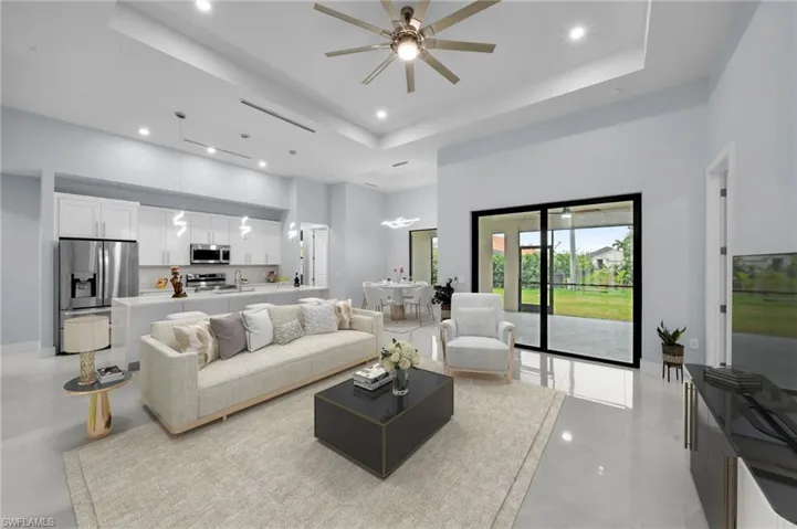 Living area with recessed lighting, a ceiling fan, a raised ceiling, and a towering ceiling