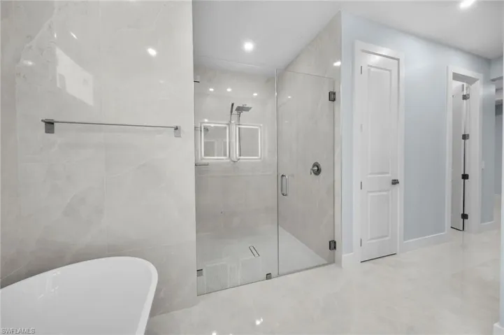 Full bathroom with a marble finish shower, a freestanding tub, and marble finish floor
