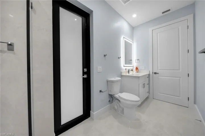 Bathroom with visible vents, baseboards, toilet, and vanity