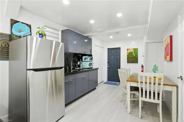 Kitchen with freestanding refrigerator, modern cabinets, gray cabinets, recessed lighting, and light wood-type flooring