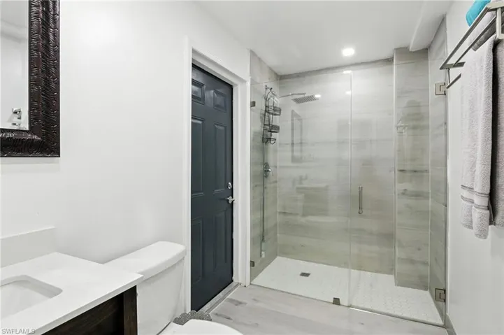 Full bath with vanity, a stall shower, recessed lighting, and light wood finished floors