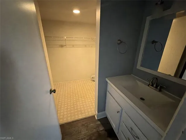 Bathroom with vanity, a walk in closet, and recessed lighting