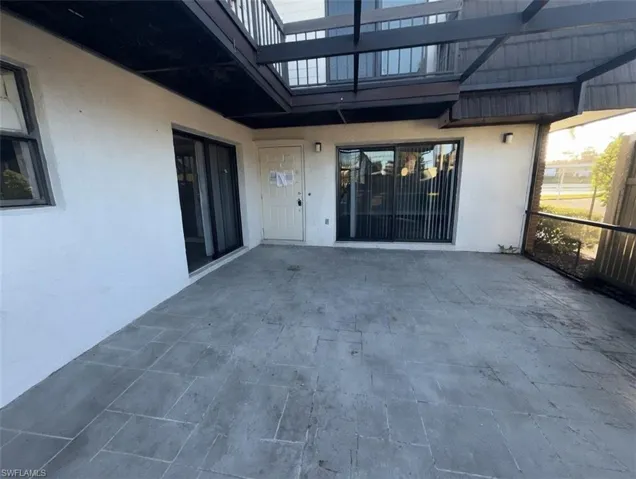 View of exterior entry with stucco siding and a patio