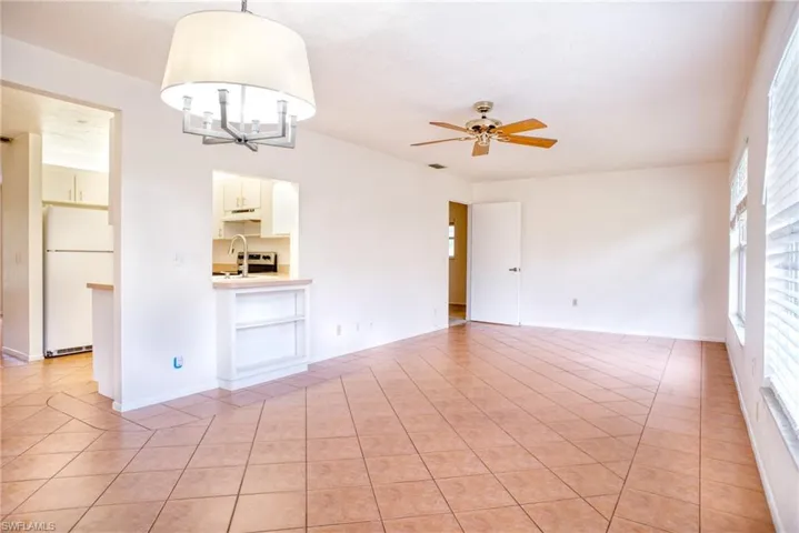 Family room featuring ceiling fan with notable chandelier