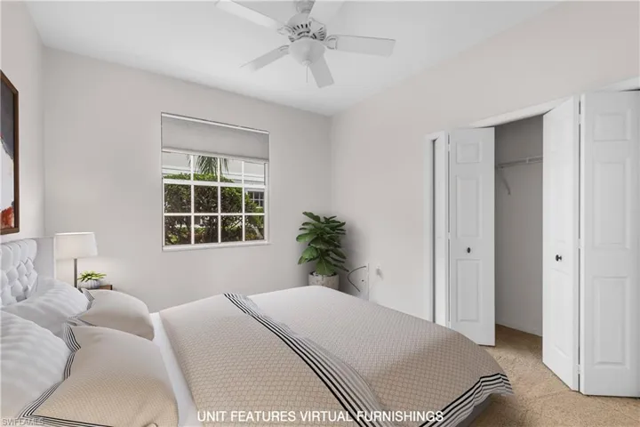 Carpeted bedroom with ceiling fan and a closet