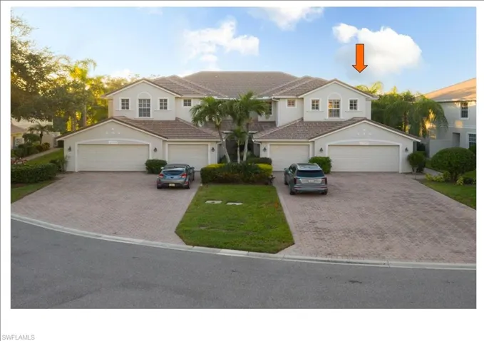 View of front of property with a garage and a front lawn