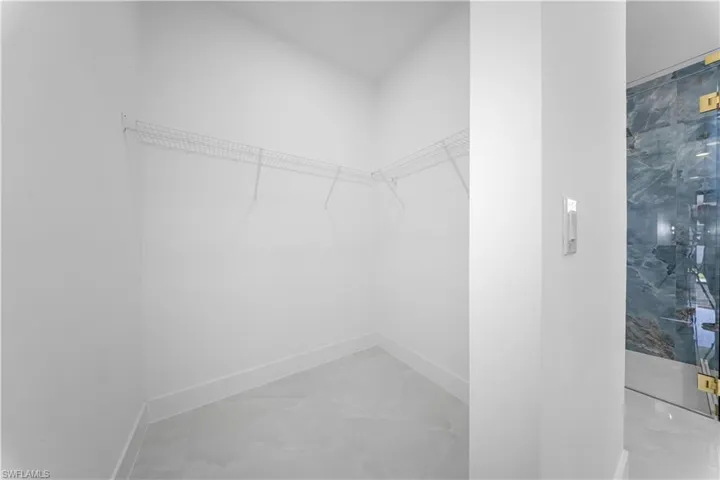 Walk in closet featuring light marble finish floors