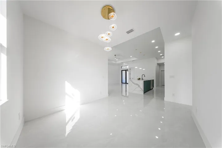 Empty room with light marble finish flooring and recessed lighting