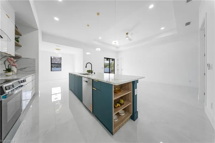 Kitchen featuring open shelves, modern cabinets, decorative light fixtures, stainless steel appliances, and recessed lighting