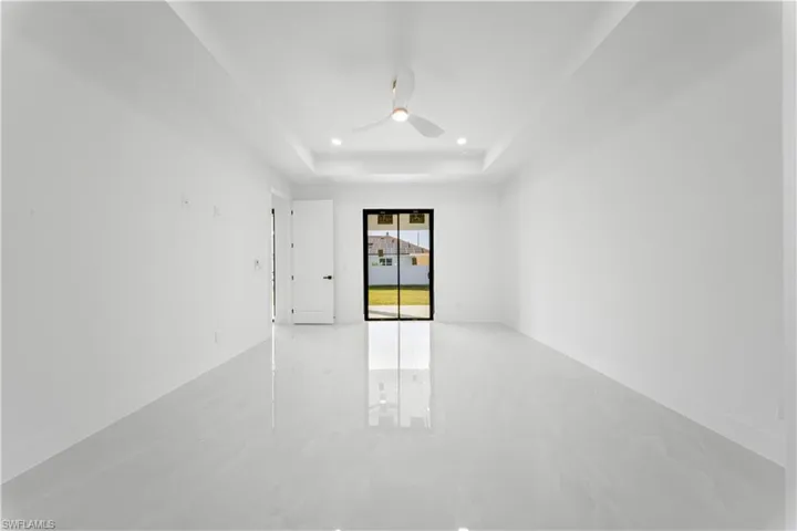 Empty room featuring recessed lighting, a tray ceiling, and a ceiling fan