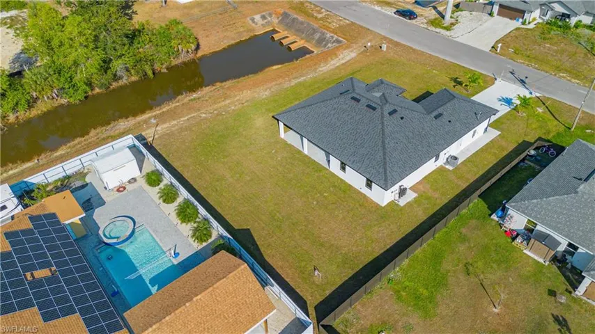 Aerial view of residential area featuring a nearby body of water
