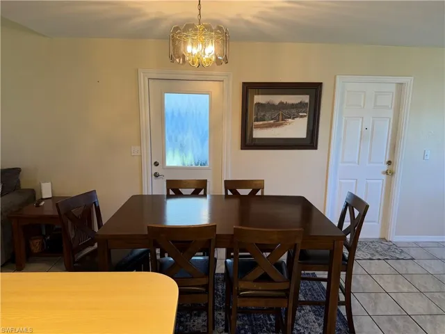 Dining room with light tile patterned floors and a chandelier