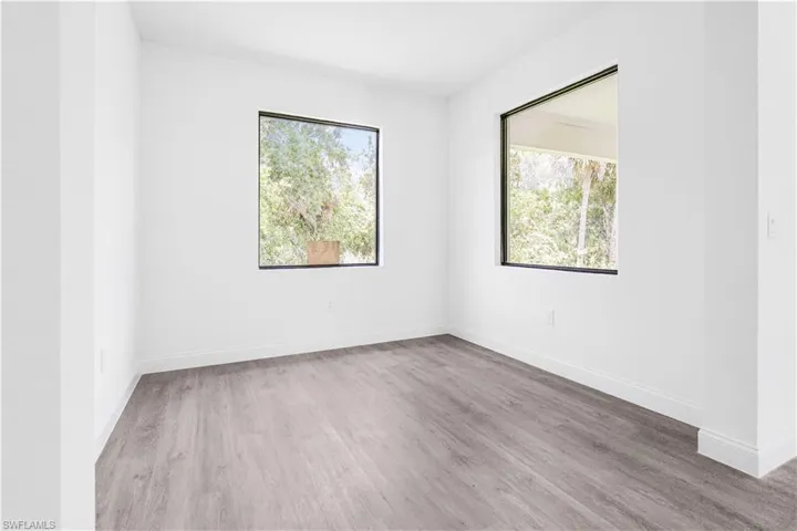 Empty room with light wood-type flooring and plenty of natural light