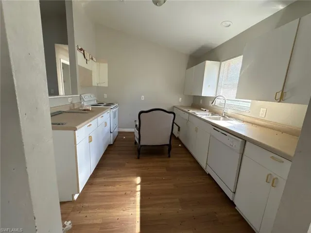 Kitchen featuring white cabinets, white appliances, and light hardwood / wood-style flooring