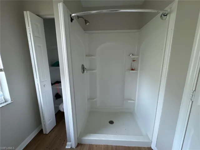 Bathroom with hardwood / wood-style floors and walk in shower