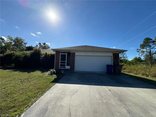 View of front of home featuring a garage and a front lawn