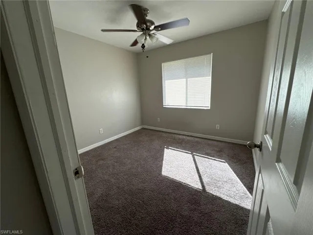 Carpeted empty room with ceiling fan