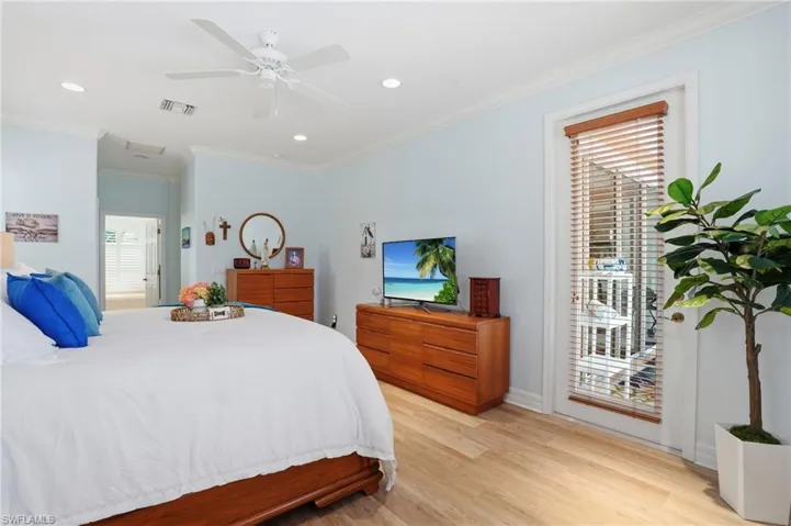 Master bedroom featuring ornamental molding, recessed lighting, light wood vinyl style floors, ceiling fan, and door to access the pool/lanai.