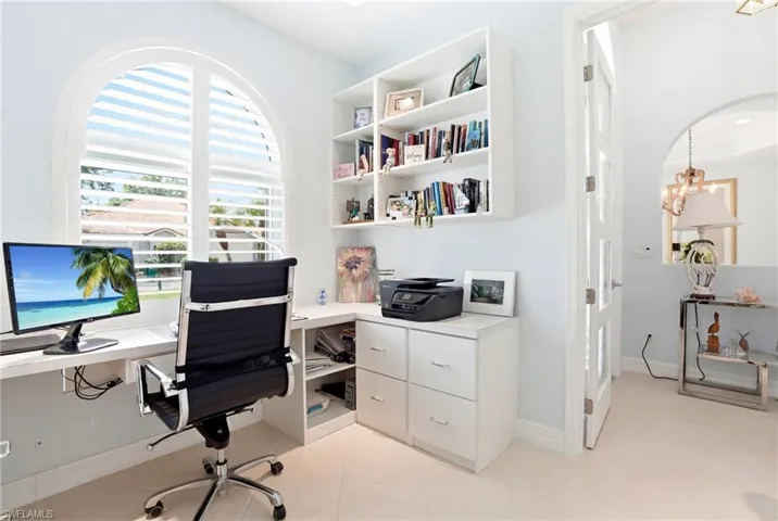 Home office with arched walkways, light tile patterned floors, and hanging lights